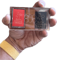 a hand holding a small box with two cards in it